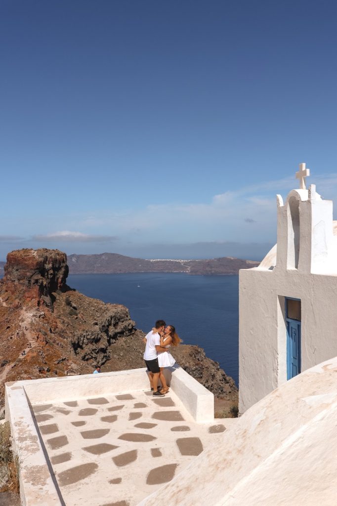 Chiesetta vicina a Skaros Rock, Santorini, coppia che si bacia col mare di sfondo