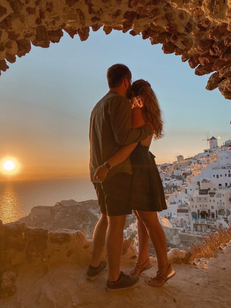 Foto da una grotta a Oia, coppia che osserva il tramonto