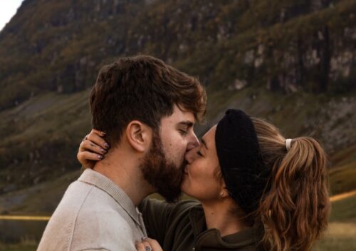 Bacio di giovane coppia e sfondo naturalistico